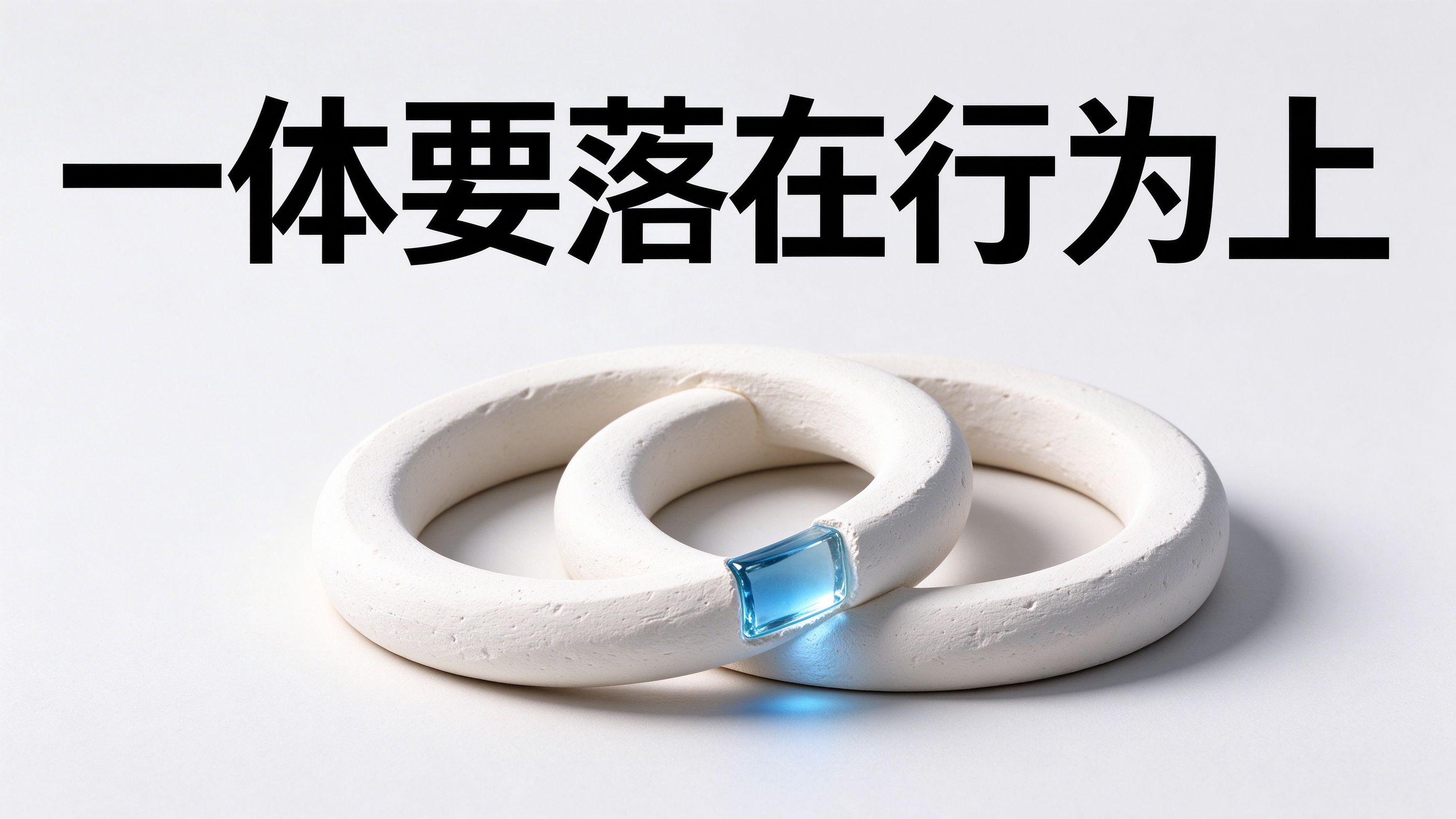 图上大字“一体要落在行为上”;画面两个相互套住的奶白石膏圆环,其中一个环接缝嵌一小块透明蓝玻璃。